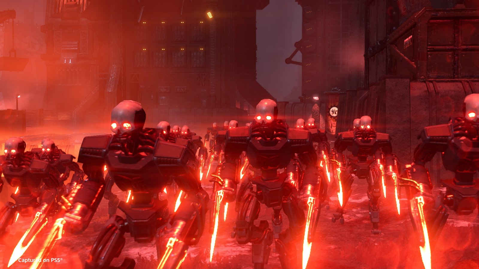 A column of skull-faced Automatons with glowing red eyes and heat blades marching through a red-lit factory city