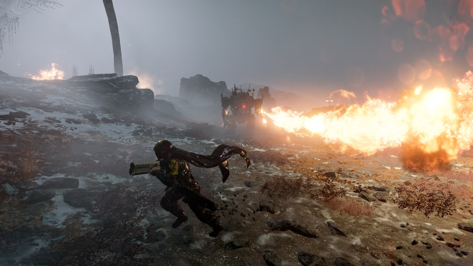 A Helldiver runs across a snowy slope away from a Hulk whose flamethrower stream sweeps toward the camera