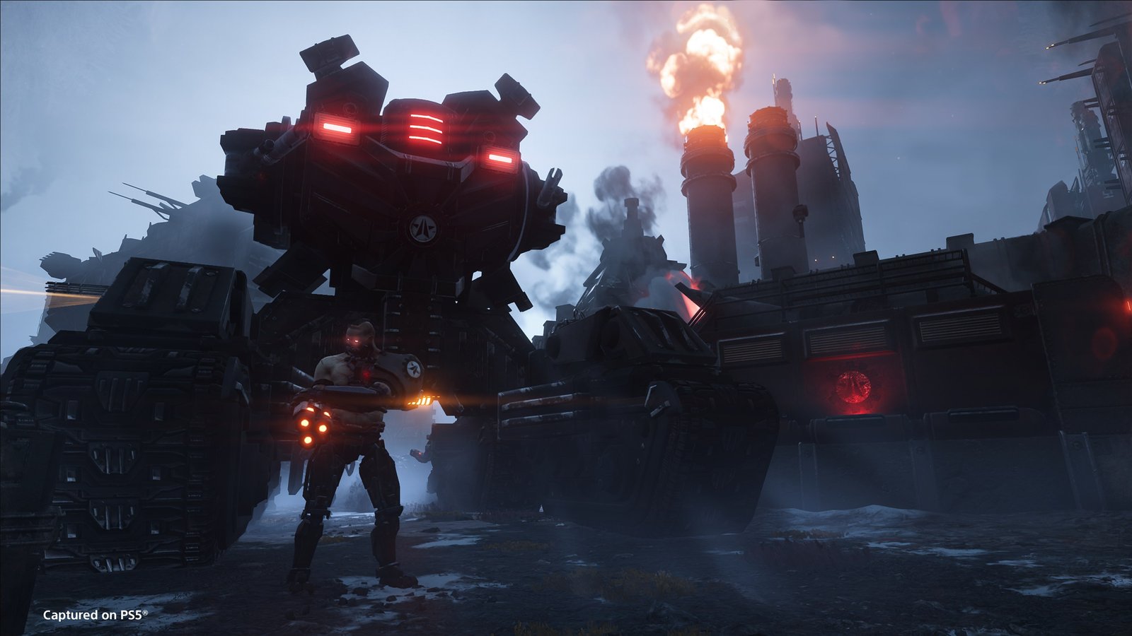 A towering tracked war machine with glowing red eyes looms behind a Cyborg soldier, factory smokestacks burning in the background