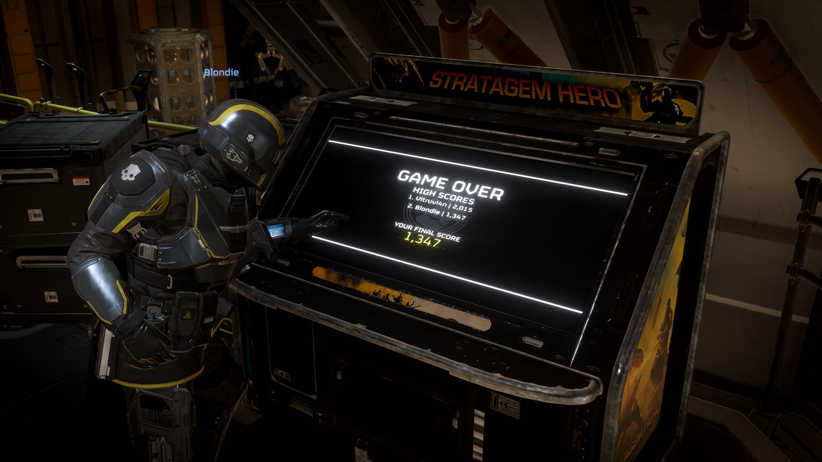 A Helldiver taps the screen of the Stratagem Hero arcade cabinet aboard the ship, which shows a game-over high-score list